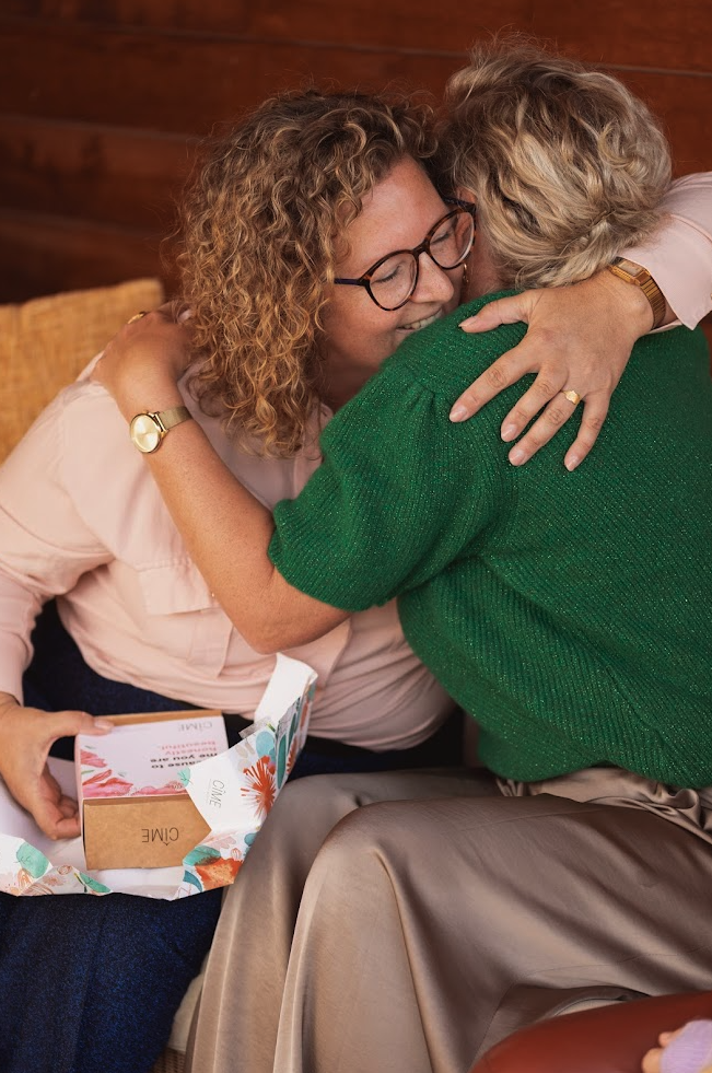 Women hugging because one gave a gift to the other