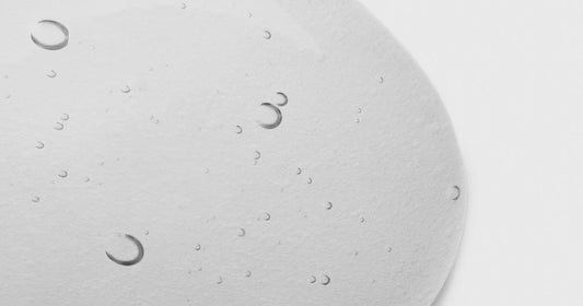Macro of a clear skincare serum swatch with fine bubbles — a science-led retinal serum texture