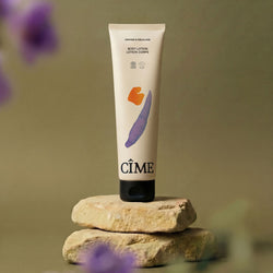 CÎME Body Lotion op natuursteen met paarse bloemen