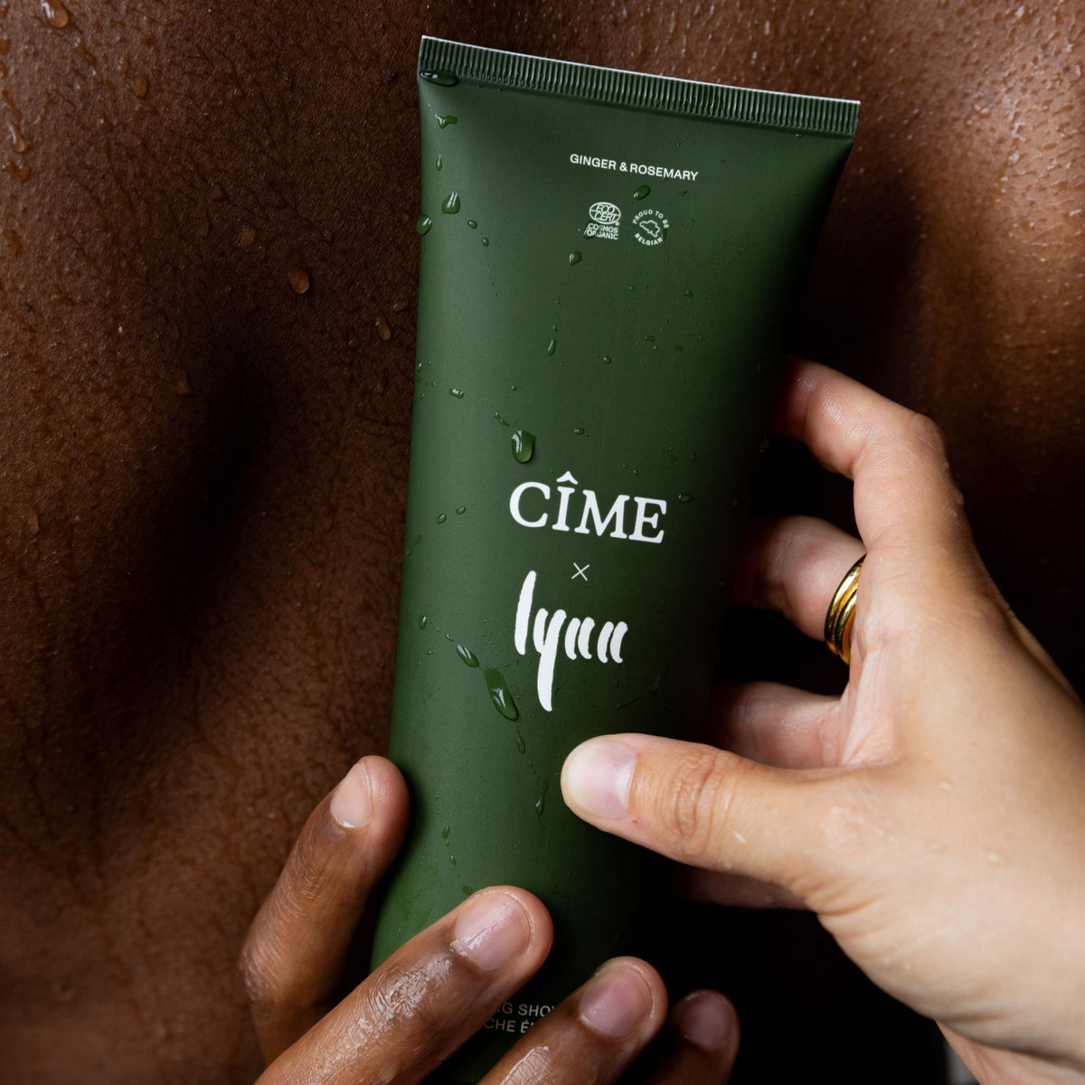 Handen houden de CÎME x Lynn Energizing Shower Gel vast