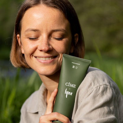 Lachende vrouw met de CÎME x Lynn Energizing Shower Gel buiten
